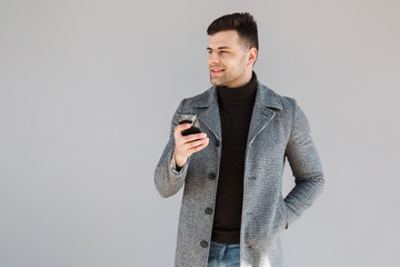 Attractive man wearing coat standing