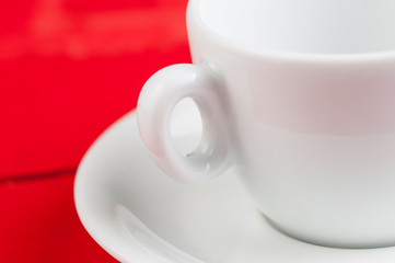 White coffee cup isolated on a red background.