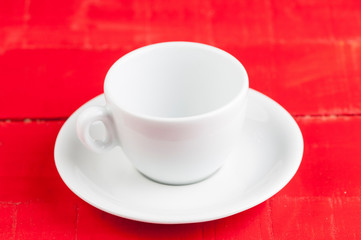 White coffee cup isolated on a red background.
