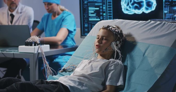 Boy lying in bed during EEG examination