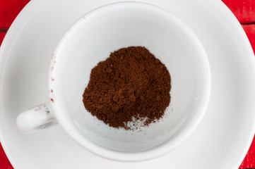 White coffee cup with metal spoon isolated on a red background.