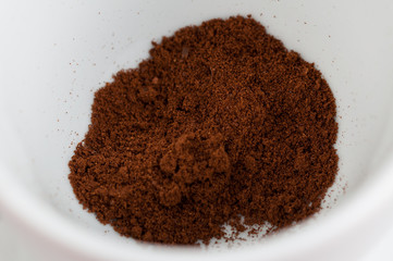White coffee cup with metal spoon isolated on a red background.