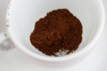 White coffee cup with metal spoon isolated on a red background.