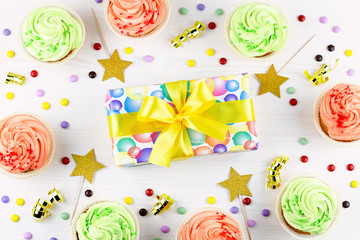 Tasty colorful cupcakes closeup and giftbox. Birthday party sweets. Happy birthday greeting card