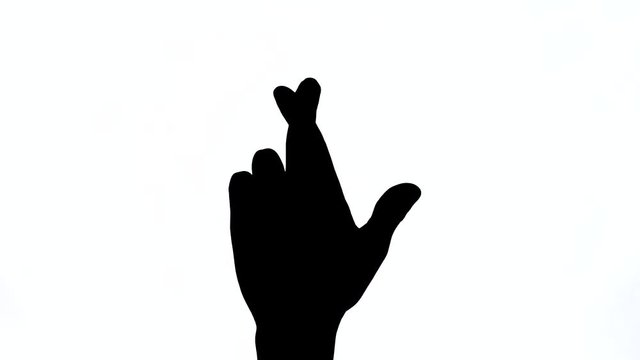 A close-up demonstration video of male hand pointing up crossed fingers gesture. Hope, anxiety, luck concept. Close-up, isolated, black and white