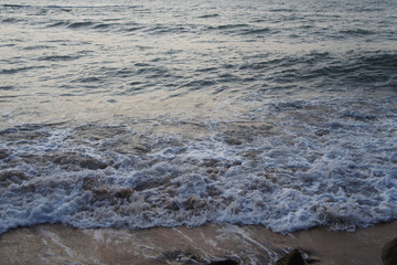 Southern tropical summer evening ocean coast at sunset. Restless sea and waves.