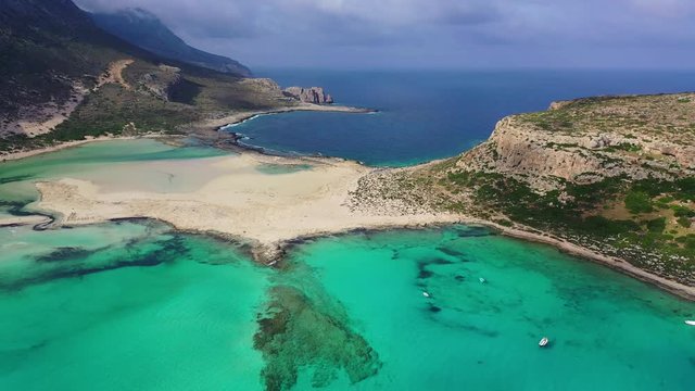 Aerial drone view video of iconic Balos beach and lagoon near Gramvousa island with turquoise clear sea and pure white sand, Crete island, Greece