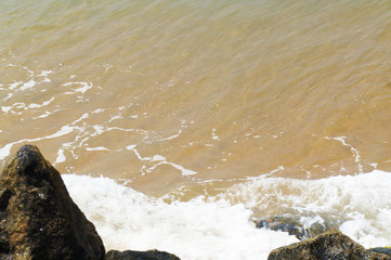 Southern tropical summer ocean coast with rocks and rocks. Lagoon with a yellow sandy beach and azure water.