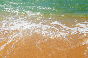 Southern tropical summer ocean coast with rocks and rocks. Lagoon with a yellow sandy beach and azure water.