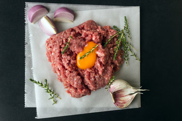 Raw minced meat with pepper, egg, herbs and  spices for cooking cutlets, burgers, meatballs. Concept- cooking, recipes, delicious dishes.