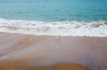 Southern tropical summer ocean coast with rocks and rocks. Lagoon with a yellow sandy beach and azure water.