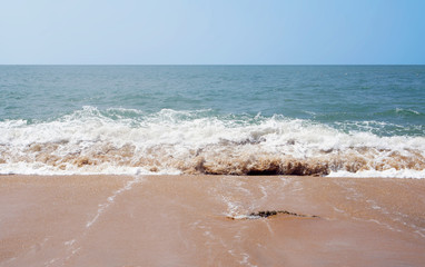 Southern tropical summer ocean coast with rocks and rocks. Lagoon with a yellow sandy beach and azure water.