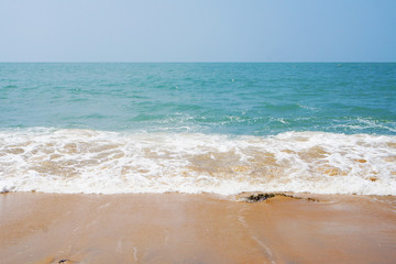 Southern tropical summer ocean coast with rocks and rocks. Lagoon with a yellow sandy beach and azure water.