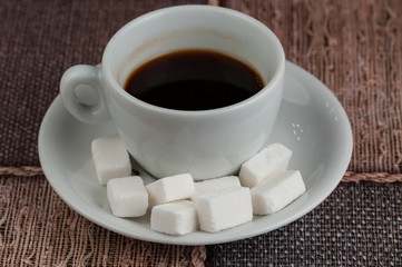 White coffee cup sugar cubes and metal spoon on table.Coffee time