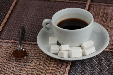 White coffee cup sugar cubes and metal spoon on table.Coffee time