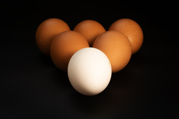 Chicken eggs in the form of a triangle on the table.