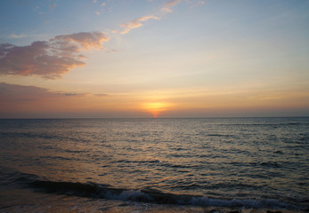 Obraz premium Southern tropical summer ocean coast at sunset. Lagoon with waves in which the sun is reflected.