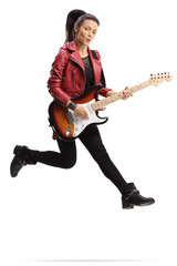 Young female guitarist playing a bass guitar and jumping