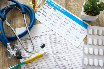 Working table in working environment of doctor or counselor in psychology practice, psychiatrist top view top-down photo. On table there are stethoscope, medicines - pills in blister and ampoules