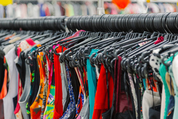 Beautiful colorful clothes in a store on hangers.