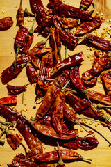 Whole dried chilli peppers with seeds lying in sunlight beam