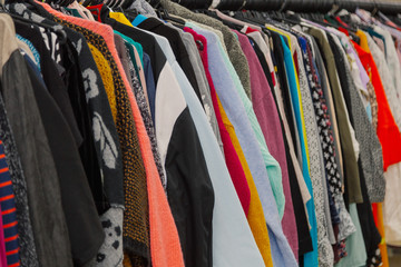 Beautiful colorful clothes in a store on hangers.