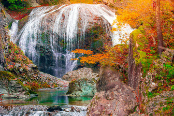 Waterfall among many foliage, In the fall leaves Leaf color change In Yamagata, Japan.Onsen atmosphere.