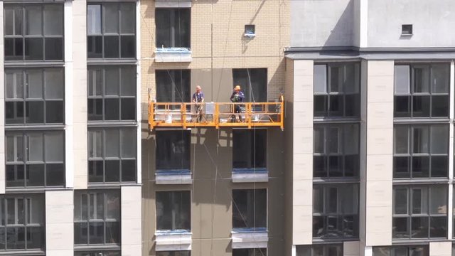 painting high-rise buildings - workers in the construction cradle, timelapse
