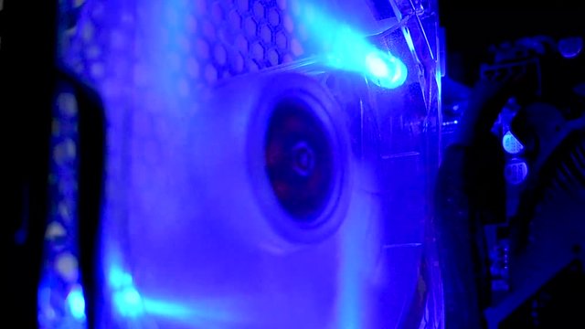 Inside gamin PC illuminated cooling fan spinning & cooling internal processor in colour changing lights.
