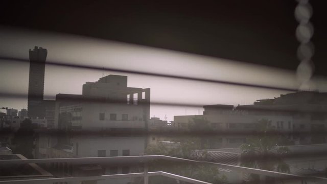 Pull focus from city outside to window blinds - camera is indoors