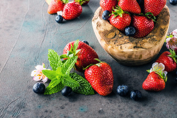 Close-up view of fresh blackberries, blueberries, strawberries and green mint leaves