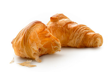 One and half baked plain croissants isolated on white.