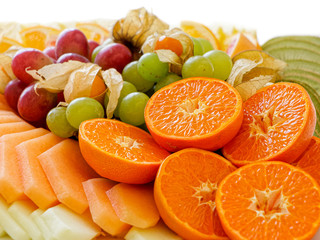 Mix of arranged freshly cut tropical and citrus fruit.