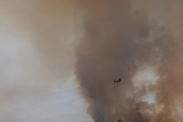 smoke on black background with helicopter fighting wildfires