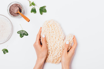 Woman's hands holding natural massage mitten washcloth