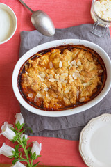 Overhead image of plum cobbler with almond flakes and cream
