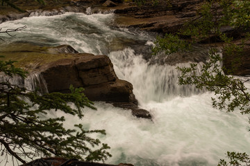 A close up of a beautiful waterfall cuts through the rocks at Maligne Canyon, Jasper National Park, Canada, short exposure to capture the power of the waterfall, nobody in the image