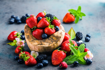 Close-up view of fresh blackberries, blueberries, strawberries and green mint leaves