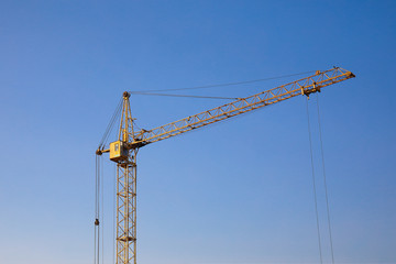 Industrial construction building crane against clear blue sky