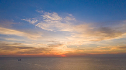 Naklejka na ściany i meble Aerial view of a Sunset sky background. Aerial Dramatic gold sunset with evening sky clouds over the sea. Stunning sky clouds in the sunset. Sky landscape. Aerial photography.