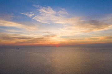 Aerial view of a Sunset sky background. Aerial Dramatic gold sunset with evening sky clouds over the sea. Stunning sky clouds in the sunset. Sky landscape. Aerial photography.