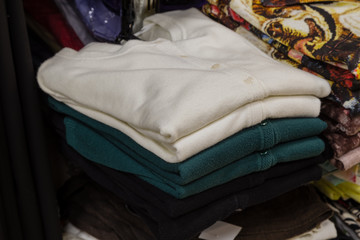 Neatly folded clothes in the store on the shelf.