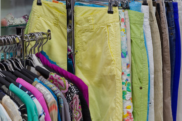 Beautiful colorful clothes in a store on hangers.