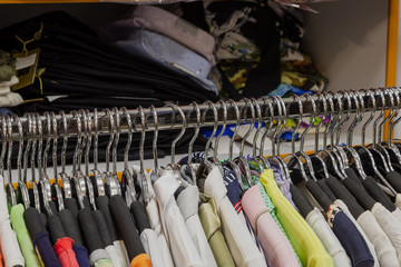 Beautiful colorful clothes in a store on hangers.