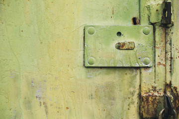 Abstract colorful wall texture and background. Close-up iron surface with yellow paint and the padlock