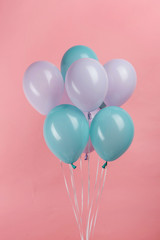 Fototapeta na wymiar blue and purple festive balloons on pink background