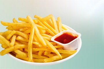 Fresh fried french fries with ketchup on wooden background