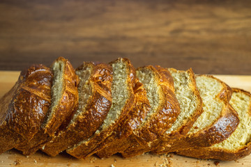 Sliced Brioche toast loaf with bread crumbs on wood cutting board	