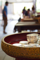 The silver bowl on the wooden tray is beautifully decorated. Being placed in the community