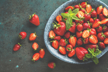 top view of fresh ripe strawberries, blueberries and blackberries on dark table with copy space
